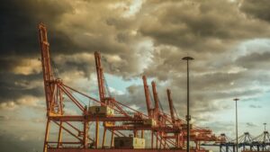 Photographie de Marios Fournaris à Perama en Grèce, grue du port maritime avec couleurs chaudes oranges et ciel nuageux
