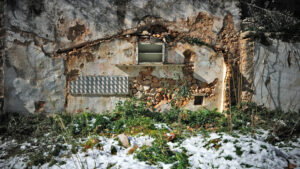 Photographie de Marios Fournaris à Perama en Grèce, détail d'une maison encastrée dans un mur. Vestige